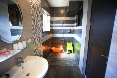 a bathroom with a sink and a shower with a yellow stool at Childlike Innocence Homestay in Ji'an