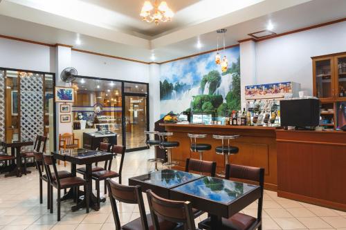 a restaurant with tables and chairs and a bar at Surin Majestic Hotel in Surin