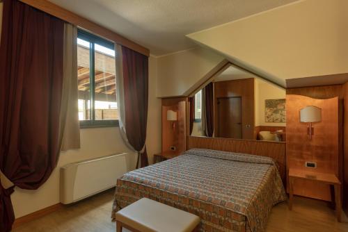 パデルノ・ドゥニャーノにあるホテル モーテル フューチュラのベッドルーム(ベッド1台、大きな鏡付)