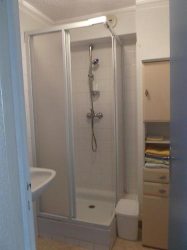 une salle de bain avec une douche avec un lavabo et des toilettes dans l'établissement résidence les oyats, à Jullouville