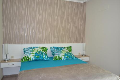 シオーフォクにあるA16 Beachapartmanのベッドルーム1室(青と緑の枕が備わるベッド1台付)