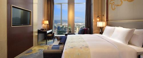 西寧市にあるWanda Vista Xiningのベッドと大きな窓が備わるホテルルームです。