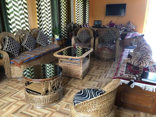 a living room filled with wicker chairs and tables at Vamoose Soshing Homestay in Ravangla