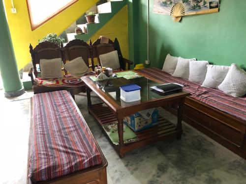 a living room with a bed and a table with at Vamoose Soshing Homestay in Ravangla