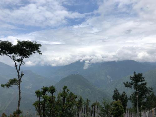 a view of a mountain range with trees in the foreground at Vamoose Soshing Homestay in Ravangla