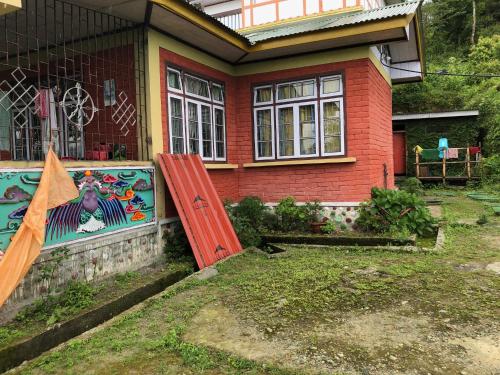 a house with a red door in front of it at Vamoose Soshing Homestay in Ravangla