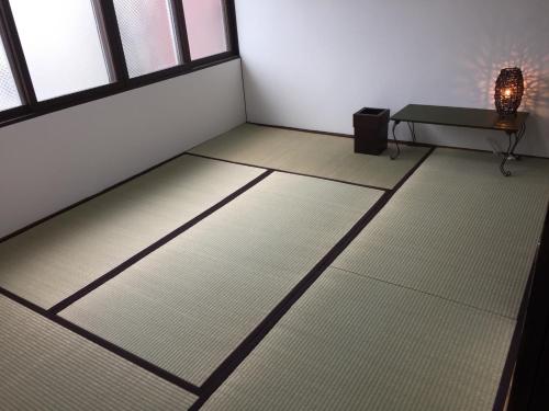 a room with white floors and a table and windows at Cool-Residence OTARU in Otaru