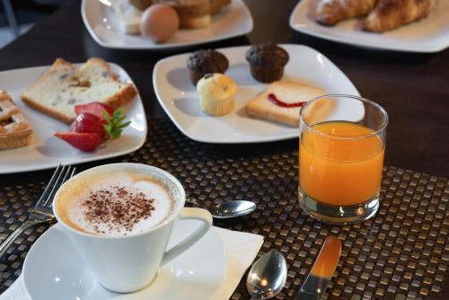 a table with plates of breakfast foods and a cup of coffee at Hotel Motel Futura in Paderno Dugnano