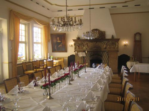 a long table in a room with a fireplace at Hotel Drei Kronen in Tecklenburg