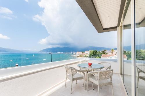 a balcony with a table and chairs and the ocean at Boka di Mare in Tivat