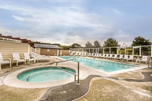 a large swimming pool with chairs and a building at Lighthouse Views in Westport
