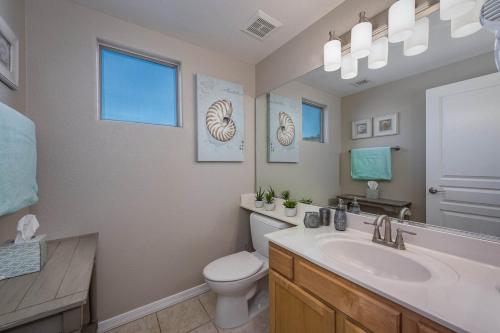 a bathroom with a sink and a toilet and a mirror at Clubgate Villa & Kierland Escape in Scottsdale