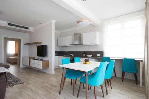 a kitchen and dining room with a table and blue chairs at Boka di Mare in Tivat