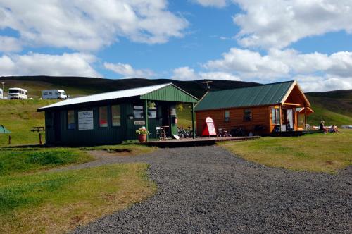 a small cabin with a green roof on a field at Hlid Bed and Breakfast in Myvatn