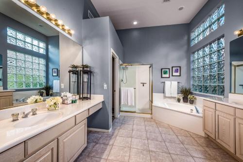 uma casa de banho com 2 lavatórios, uma banheira e um chuveiro em Desert Foothills em Phoenix