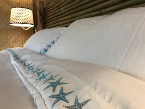 a white bed with blue star cushions on it at Volcano Eco Cabin & Eco Lodge in Volcano