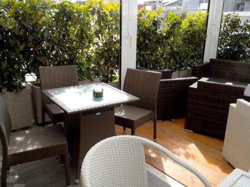 a table and chairs on a patio with plants at Hotel Briganti in Qualiano