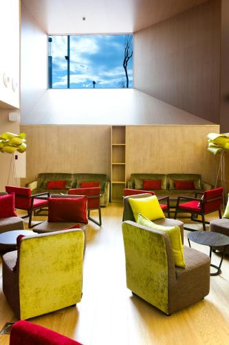 a waiting room with couches and chairs and a window at Atenea Port Barcelona Mataró in Mataró