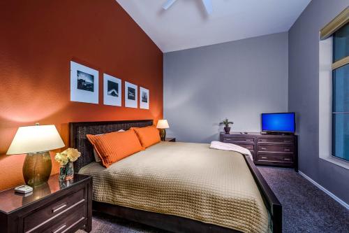 een slaapkamer met een bed met een oranje muur bij Desert Foothills in Phoenix