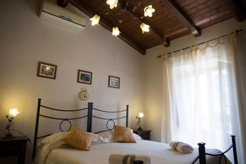 1 dormitorio con 2 camas y ventana en B&B Al Centro Storico, en Nicolosi