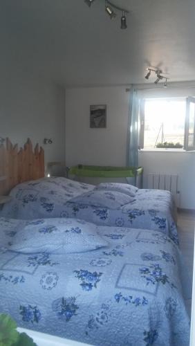 une chambre avec un lit avec une couette bleue et blanche dans l'établissement Gite entre terre et mer, à Machy