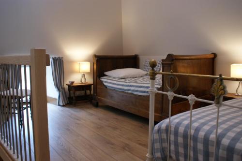 a bedroom with a bed and a table with a lamp at Les FREJALS in Compeyre