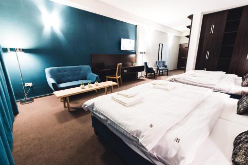a hotel room with two beds and a chair at BOUTIQUE HOTEL11 with rooftop SPA in Nitra