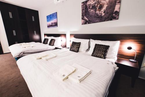 a bedroom with two beds with white sheets and pillows at BOUTIQUE HOTEL11 with rooftop SPA in Nitra