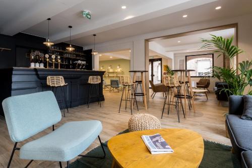 - un salon avec un bar, des tables et des chaises dans l'établissement Hôtel du Beffroi Gravelines Dunkerque, à Gravelines