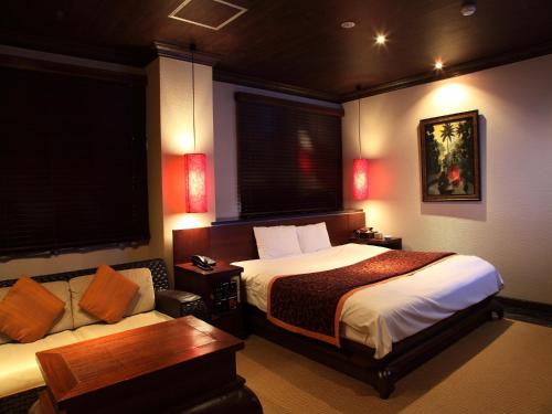 Habitación de hotel con 2 camas y sofá en Hotel Cuna Kyoto Love Hotel, en Kioto