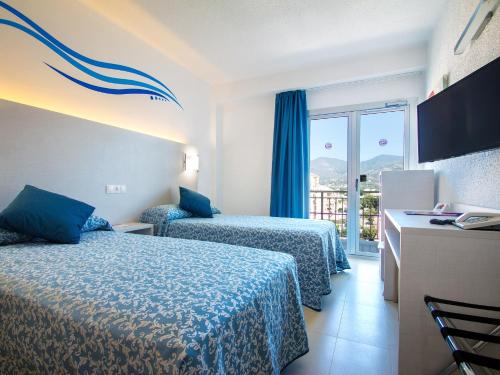 a hotel room with two beds and a window at Hotel Servigroup Trinimar in Benicàssim