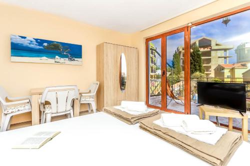 um quarto com uma cama, uma televisão e uma varanda em Jovan Apartments em Petrovac na Moru
