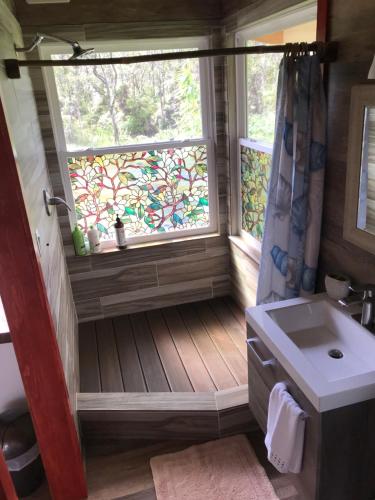 a bathroom with a sink and a window with a shower at Volcano Eco Cabin & Eco Lodge in Volcano