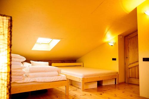 a yellow room with a bed and a skylight at Akmeninis Bebras in Zhemoytele