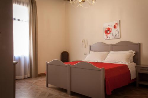 a bedroom with a bed with a red blanket at Case Vacanze Al Duomo in Licata