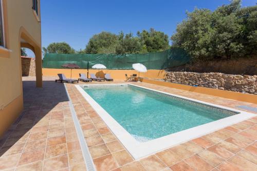 a swimming pool in a villa with a stone wall at Casa da Falfeira B&B in Lagos
