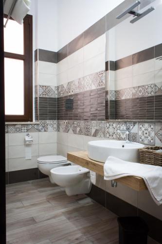 a bathroom with two toilets and a sink at Case Vacanze Al Duomo in Licata