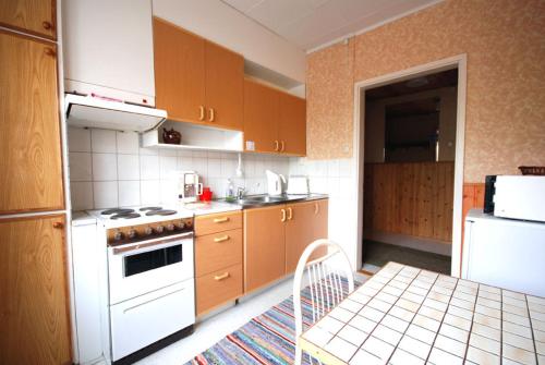 a kitchen with wooden cabinets and a white stove top oven at Jämsän Gasthaus in Jämsä