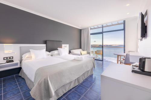 a hotel room with a bed and a view of the ocean at Hotel Mirador Papagayo by LIVVO in Playa Blanca