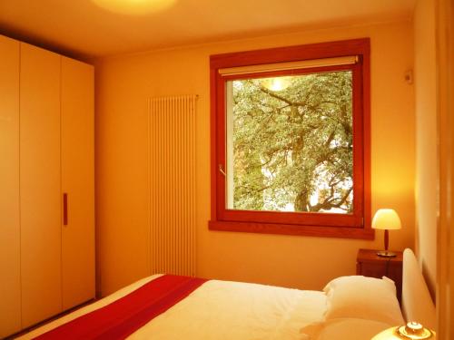 a bedroom with a bed and a window at Al Chiarè in Oggiono