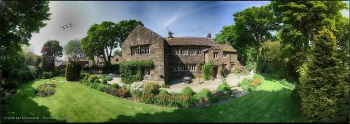 a large stone house on a green lawn at Hurstwood Hall in Burnley
