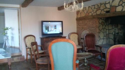 une chambre avec des chaises, une télévision et une table dans l'établissement Gite entre terre et mer, à Machy
