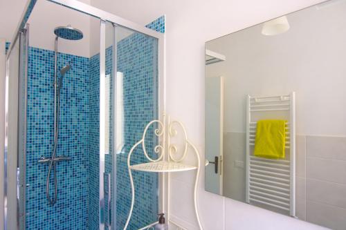 uma casa de banho com um chuveiro e um espelho. em Appartamento Tadolini em Roma