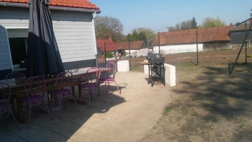 un patio avec une table, des chaises et un grill dans l'établissement Gite entre terre et mer, à Machy