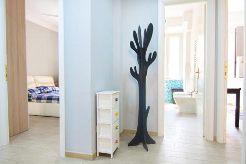 a bedroom with a black tree stenciled on the wall at Appartamento Tadolini in Rome