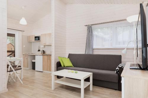 a living room with a couch and a table at Domki "Arkadia" in Pobierowo