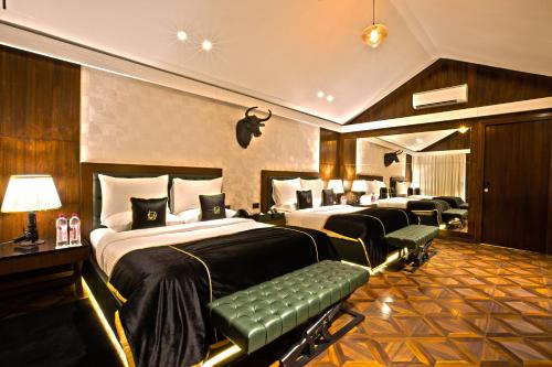 een hotelkamer met 2 bedden en een bank bij DATA Resort by Della Adventure in Lonavala