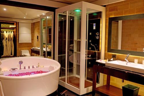 a large bathroom with a tub and a sink at DATA Resort by Della Adventure in Lonavala