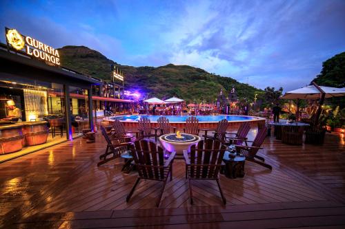 a restaurant with a table and chairs on a deck at DATA Resort by Della Adventure in Lonavala