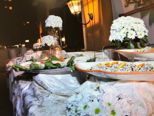 a table topped with plates of food and flowers at Grand Hotel Montesilvano in Montesilvano